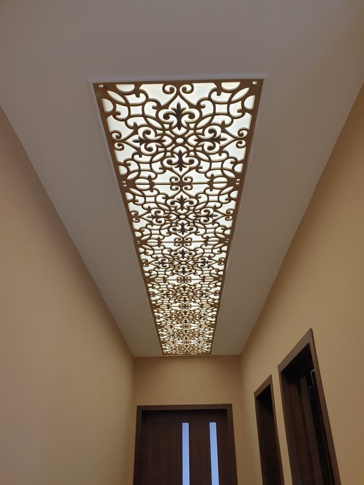 the ceiling in this hallway is decorated with intricate designs and lights, along with two doors