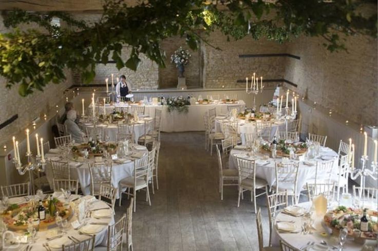 a room filled with tables and chairs covered in white linens