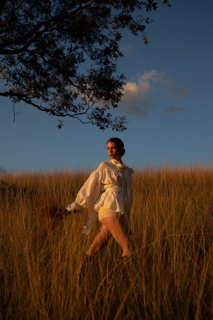 a woman is standing in the tall grass