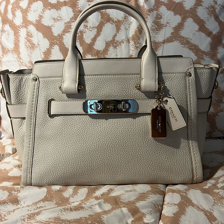 This Is A Very Very Gently Used (Twice) Coach Handbag. It's Basically Brand New! I Have The Tags Still. It's Absolutely Beautiful. I Love It! It's The Color Chalk Per The Tags. It's That Perfect Cream Color Every Woman Needs In Her Closet To Go With Anything. And It Has Gold Accents. I Have Had It In A Duster Bag Which Is Included If You Want It. The Duster Bag Is Stained Per Storage But The Bag Itself It's Basically Brand New!! It Comes With Straps To Make It A Satchel Or Keep It As A Handbag. Chic White Satchel With Metal Hardware, White Shoulder Bag With Metal Hardware For Travel, Classic Satchel With Silver-tone Hardware For Errands, Beige Top Handle Satchel With Silver-tone Hardware, White Tote Shoulder Bag With Metal Hardware, Beige Top Handle Bags With Silver-tone Hardware, Coach White Bag With Branded Hardware, White Coach Bag With Branded Hardware, Beige Bag With Silver-tone Hardware And Double Handle