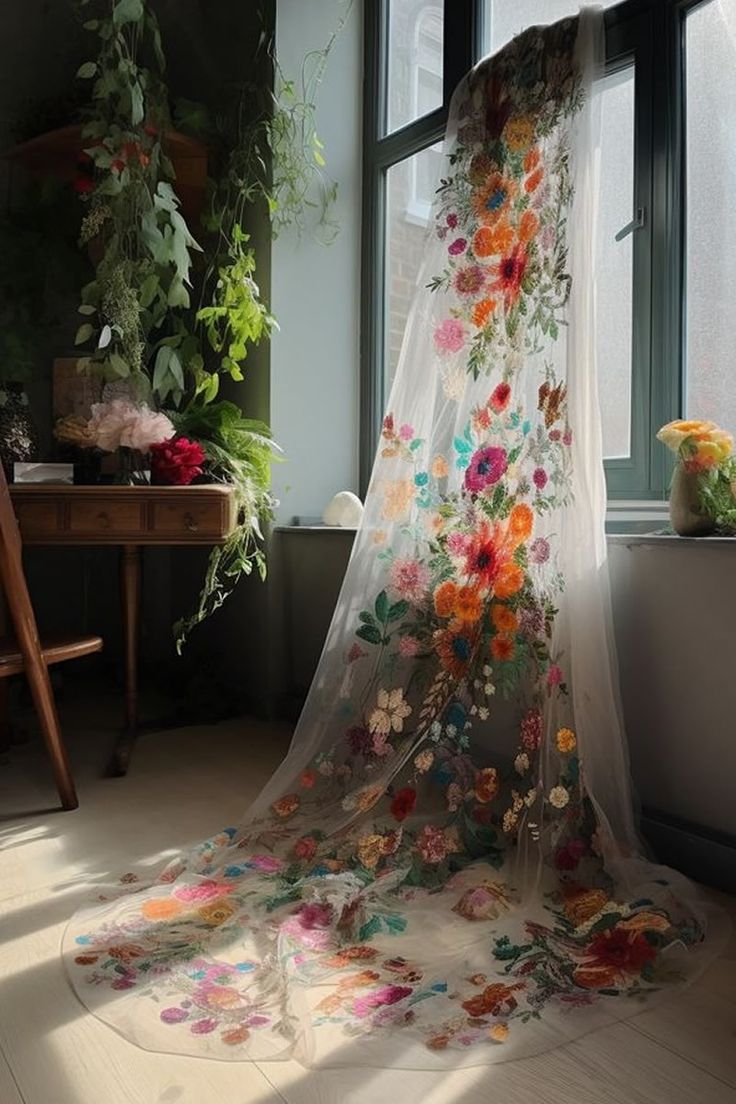 a sheer curtain with flowers on it in front of a window