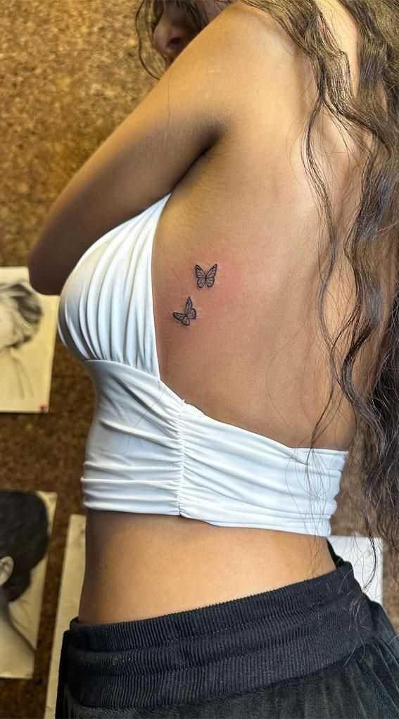 a woman with a butterfly tattoo on her back