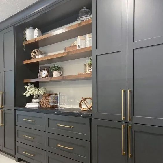 a kitchen with black cabinets and gold handles