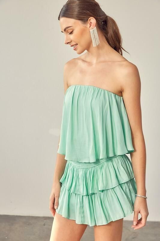 STYLE INFORMATION: The Monaco Milky Green Strapless Romper is a vacay dream! Light green woven fabric falls from a strapless neckline, with no-slip strips, to a flowy, ruffle overlay bodice with an on-trend smocked overlap back detail. Attached shorts complete the look. DETAILS & CARE: Lined Polyester/Rayon. Hand wash cold. Imported. SHIPPING: We offer free shipping for all orders in the Continental US. Strapless Ruffle Dress For Vacation, Strapless Ruffled Dress For Vacation, Strapless Dress With Ruffles For Vacation, Summer Beach Tube Top With Ruffles, Summer Beach Ruffled Tube Top, Off-shoulder Tube Top For Summer Brunch, Casual Strapless Ruffled Dress For Vacation, Casual Strapless Dress With Ruffles For Vacation, Off-shoulder Tube Top For Brunch