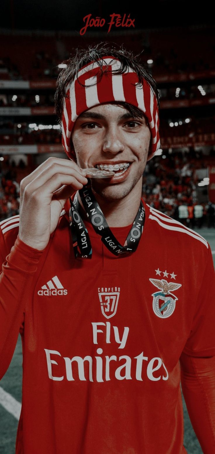 a man with a scarf around his head is posing for a photo at a soccer game