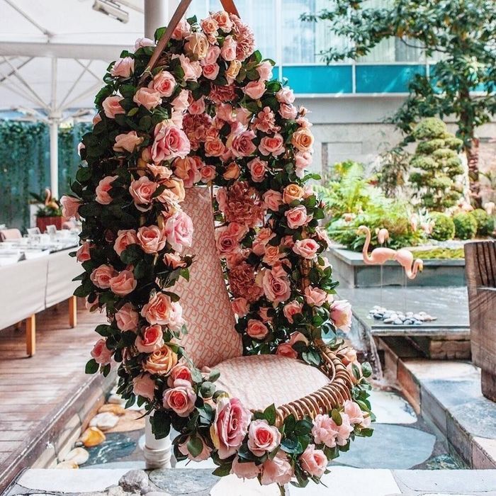 a chair covered in flowers sitting on top of a table