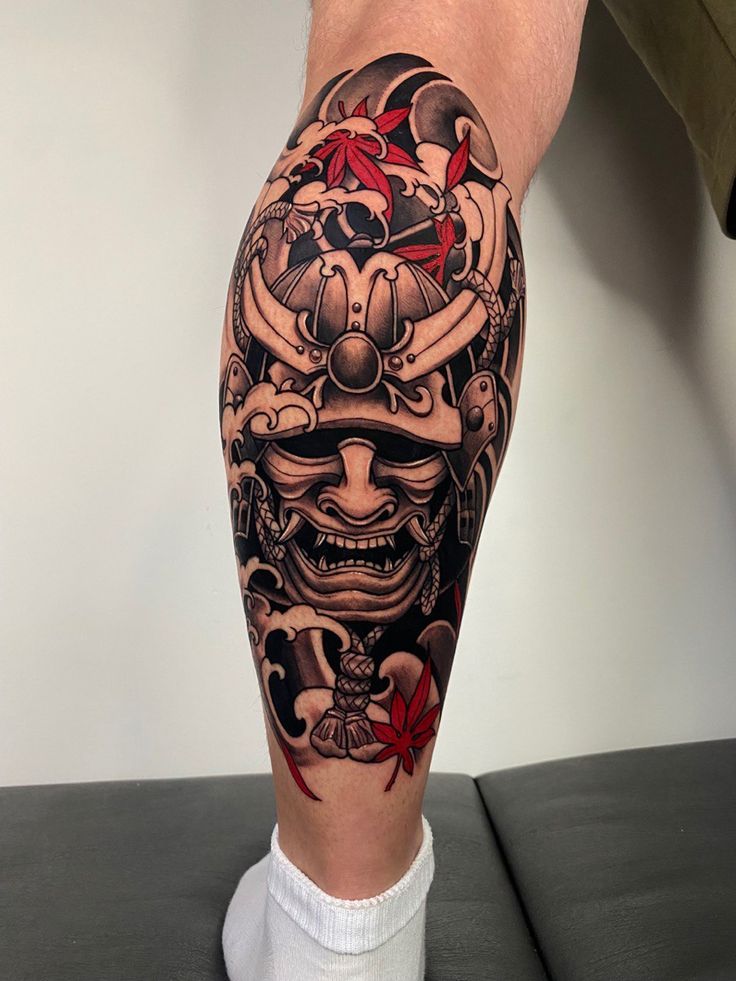 a man's leg with a tattoo on it and an image of a demon