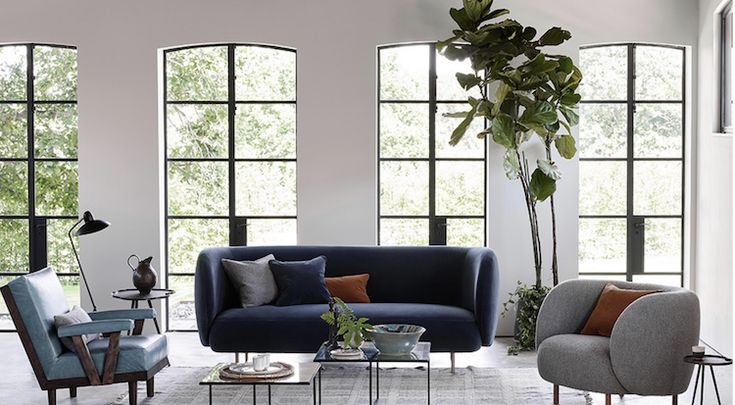 a living room filled with furniture and large windows