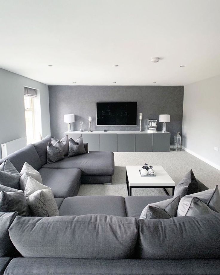 a living room filled with furniture and a flat screen tv mounted to the side of a wall