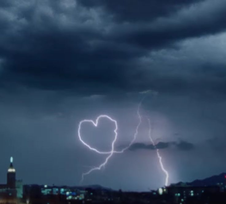 a couple of lightning strikes in the sky over a city