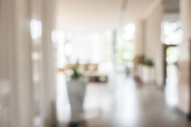 blurry photograph of an open hallway with white walls and columns in the foreground