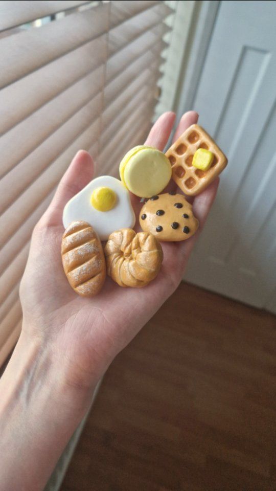 a person holding some food items in their hand with the blinds closed behind them,