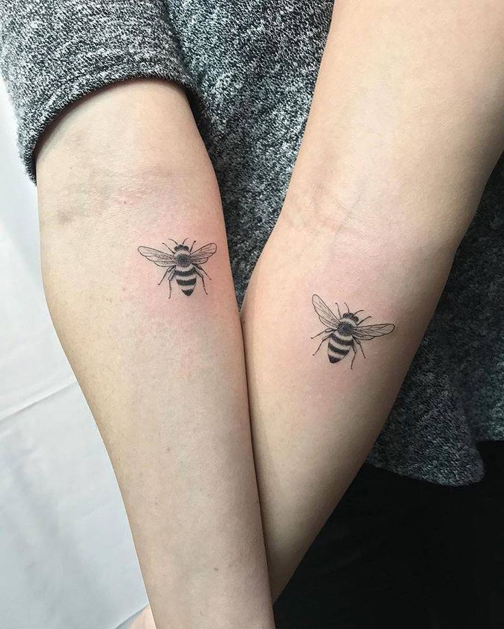 two people with matching tattoos on their arms, one has a bee and the other has a