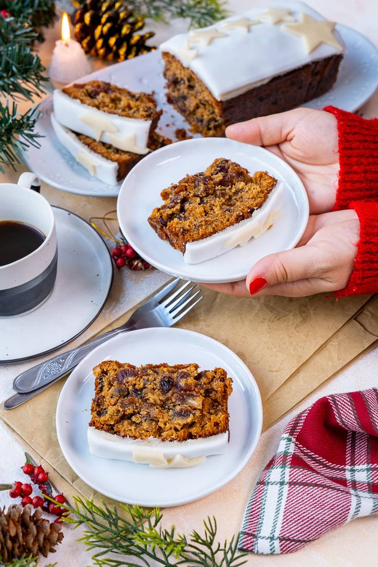 two hands holding plates with slices of cake on them and coffee in front of them