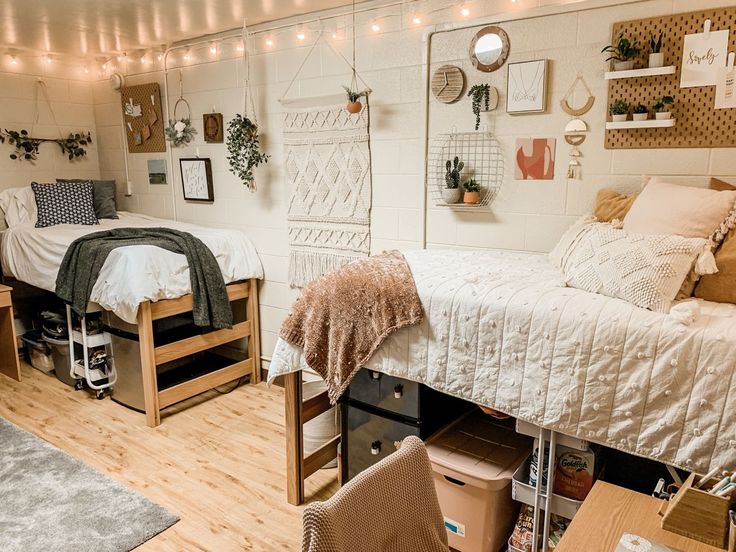 a dorm room with two beds, desks and lights on the wall above them