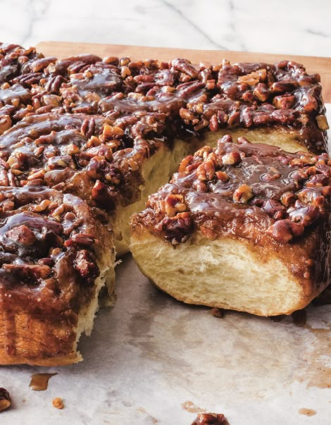 a large piece of bread with nuts on it and one slice cut out from the side