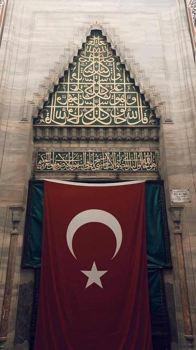 a large flag hanging from the side of a building with an intricately decorated doorway