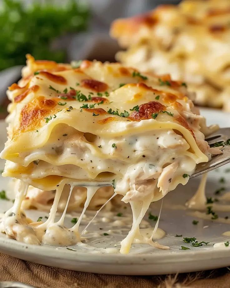 a slice of lasagna being lifted from a plate with the rest of the casserole