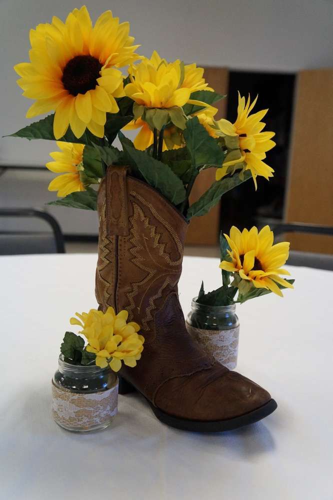 a pair of cowboy boots with sunflowers in them are sitting on a table