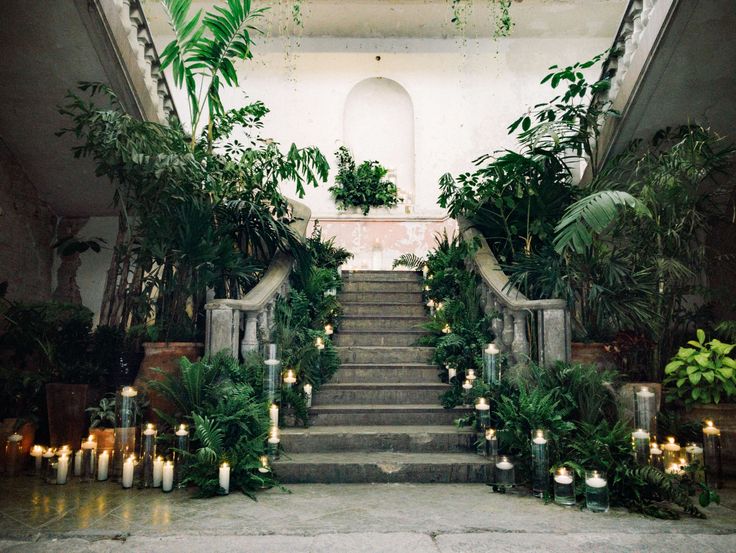 the stairs are lined with candles and greenery