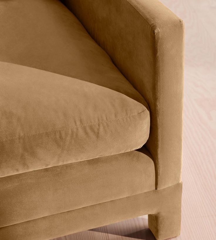 a tan couch sitting on top of a wooden floor