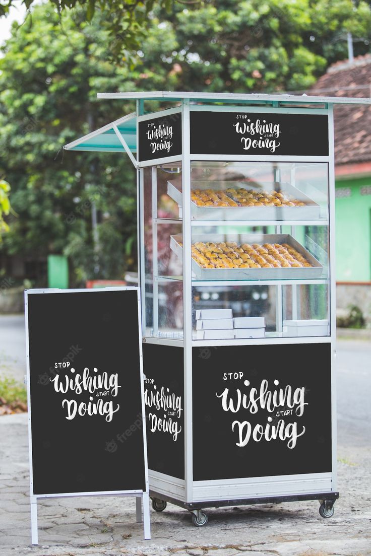 a display case with donuts in it on the side of the road next to trees