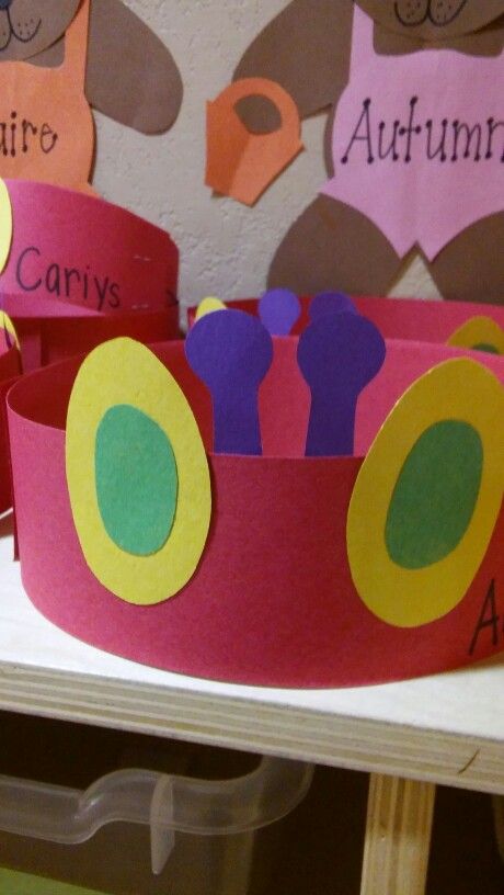 three paper crowns with animals on them sitting on top of a table in front of a wall