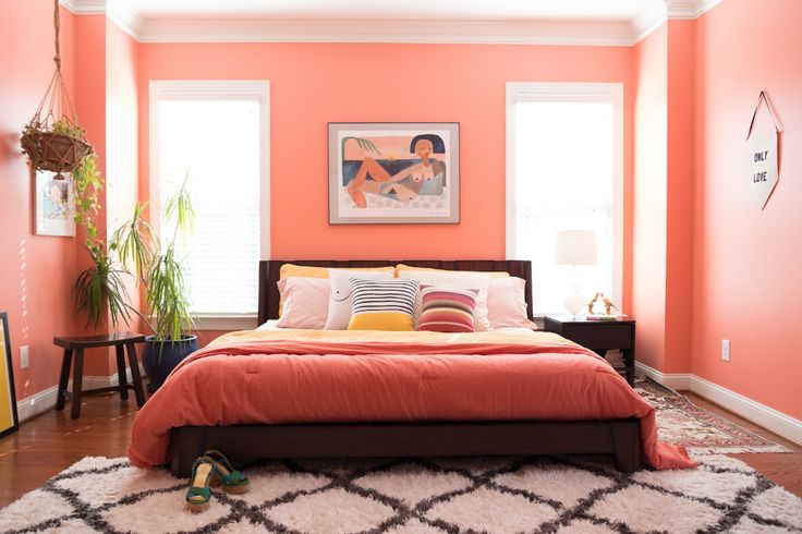 a bedroom with orange walls and white carpet