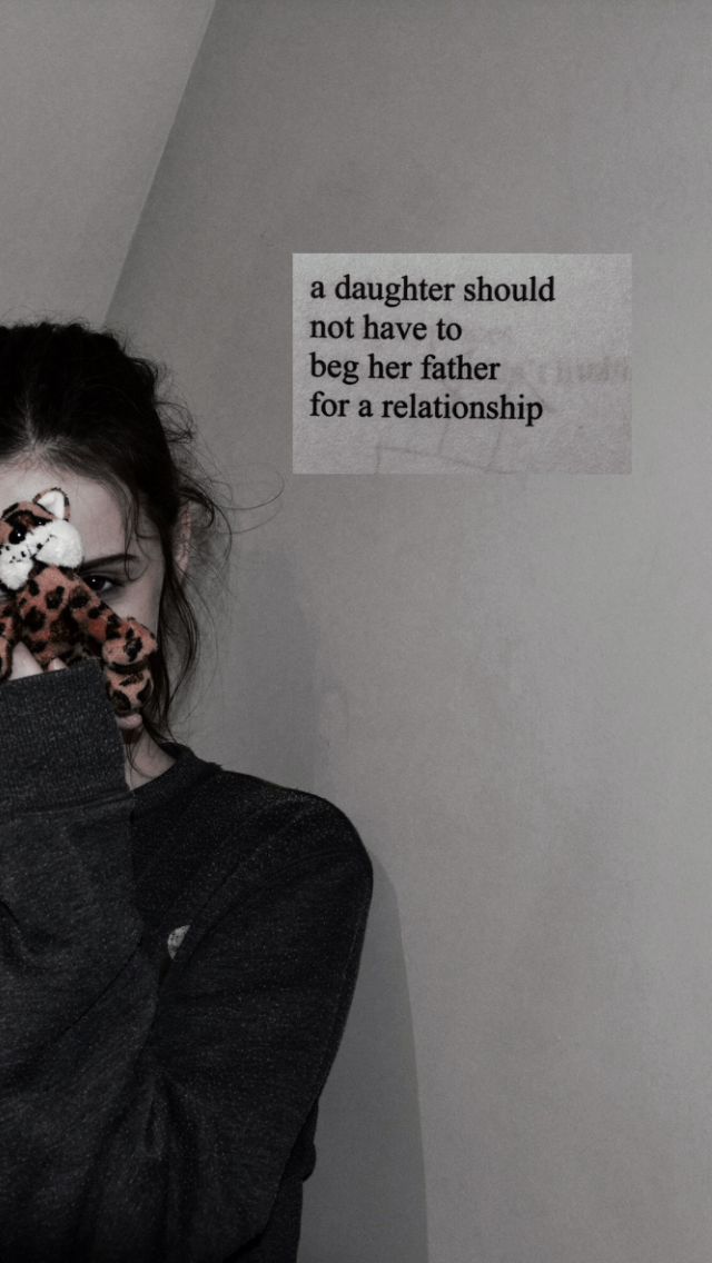 a woman with her face covered by a leopard print scarf, standing in front of a wall