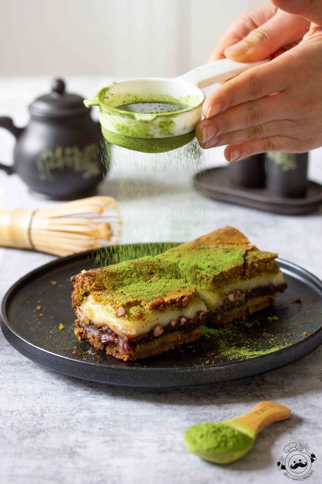 someone is sprinkling pesto on a piece of toasted bread with green sauce