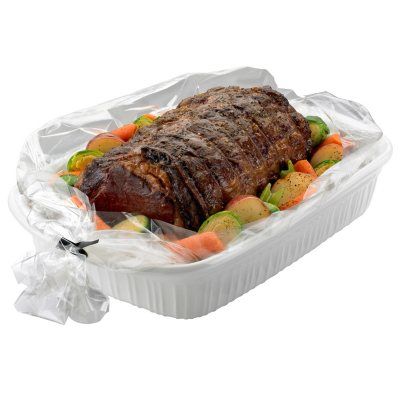 a piece of meat wrapped in plastic on top of a white container filled with vegetables