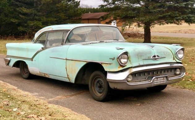 an old car is parked on the side of the road