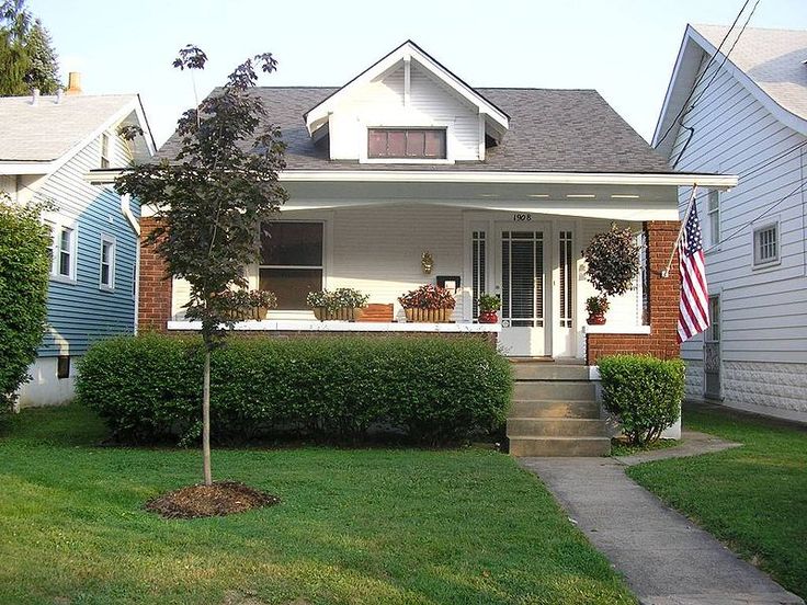 a small white house sitting on top of a lush green field