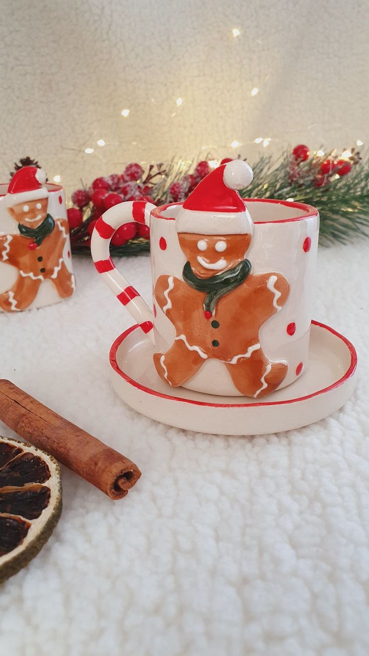 two cups and saucers decorated with gingerbreads, candy canes and cinnamon sticks