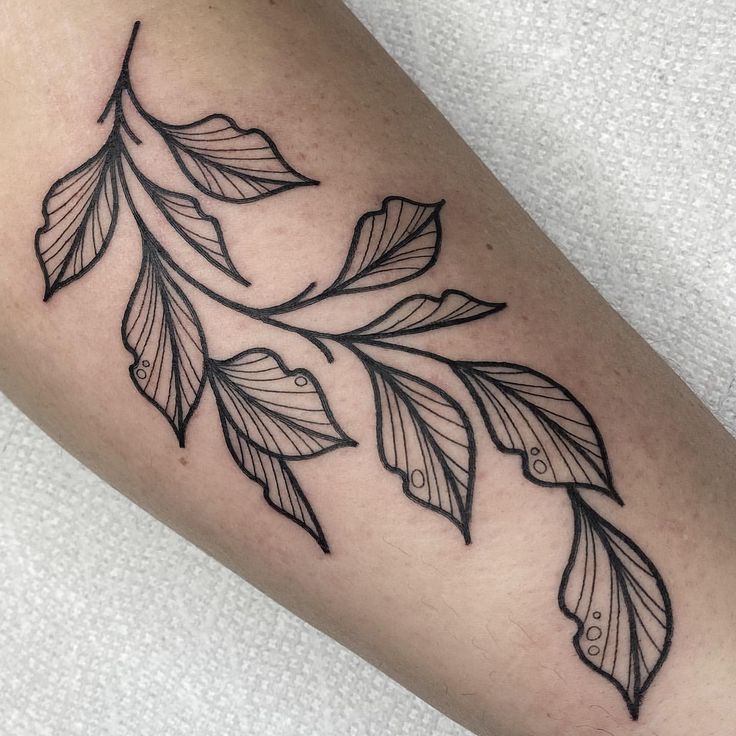 a black and white photo of a leaf tattoo