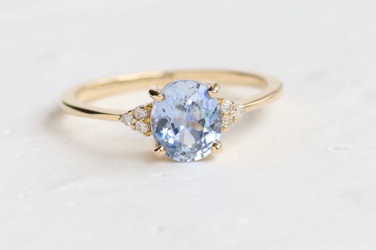 Natural LightBlue Sapphire Diamond Ring Handmade with 14k Yellow Gold. This beautiful simple ring features natural Ceylon light blue sapphire stone its quite beautiful and has a perfect cut. A perfect simple gift for giving to your friend, wife or mother. ◉ Setting: - Metal: 14k Yellow Gold - Band width: 1.2-1.4mm - Size: Personalized (choose at checkout) - Total weight: 1.73g ◉ Center Stone: - Type: Natural, Ceylon light blue sapphire - Shape: Oval - Weight: 1.20 ct - Origin: Ceylon (Sri Lanka) Oval Light Blue Promise Ring, Light Blue Oval Promise Ring, Blue Oval Dainty Birthstone Ring, Dainty Blue Oval Rings, Light Blue Sapphire Ring, Light Blue Sapphire Engagement Ring, Light Blue Ring, Peach Sapphire Rings, Ring For Mom