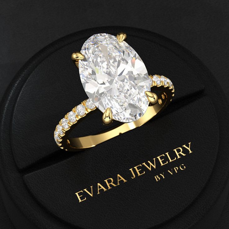 an oval shaped diamond ring on top of a black box with the name eva jewelry