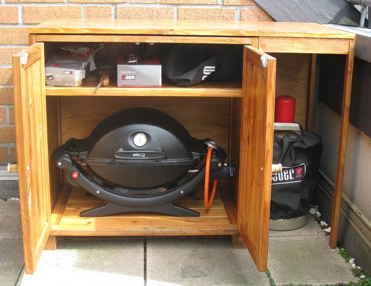 an open cabinet with a helmet on top and other items in the back ground next to it