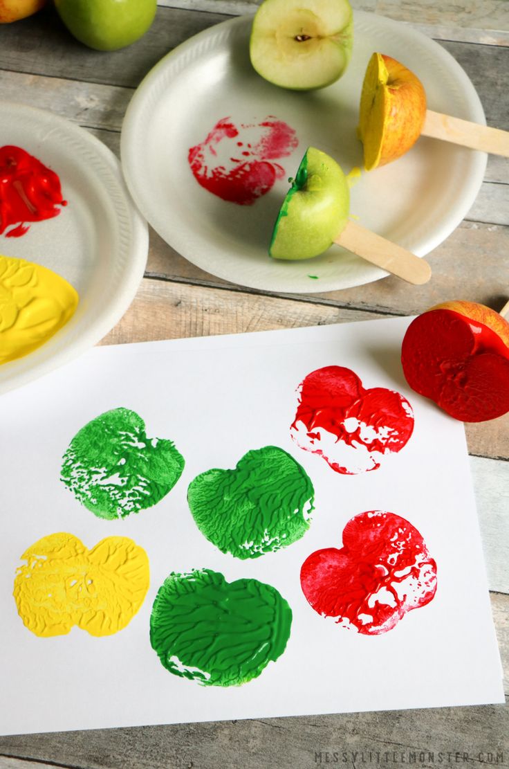 apples and hearts are painted on paper with popsicle stickers next to the apple slices