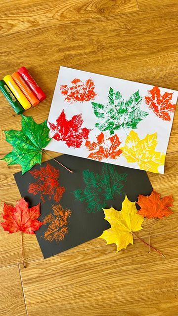 fall leaves and crayons laid out on a wooden floor with colored crayons