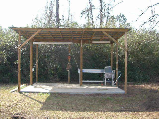 a covered picnic area in the middle of a wooded area