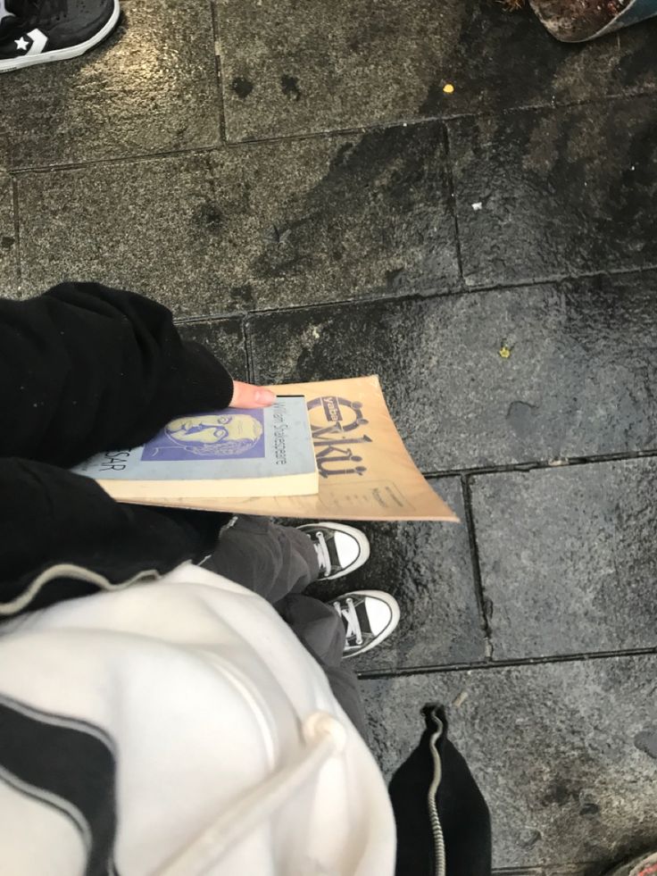 a person sitting on the ground reading a book