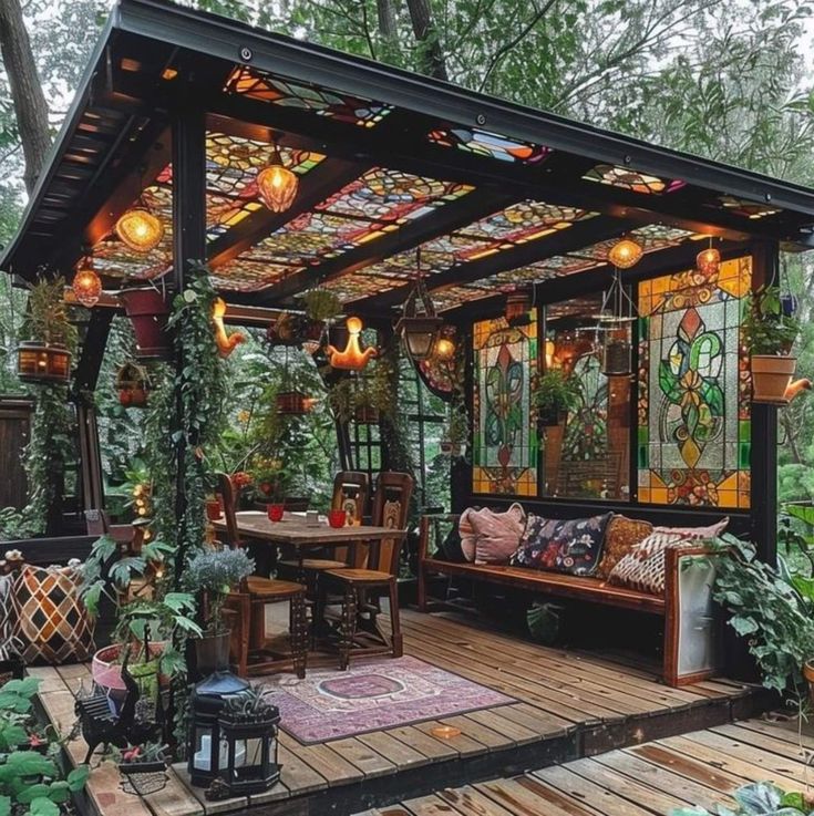 a covered patio with lots of plants and lights on the ceiling, surrounded by greenery