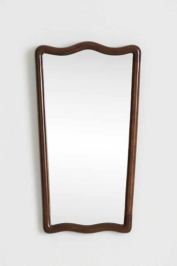 a wooden mirror hanging on the wall