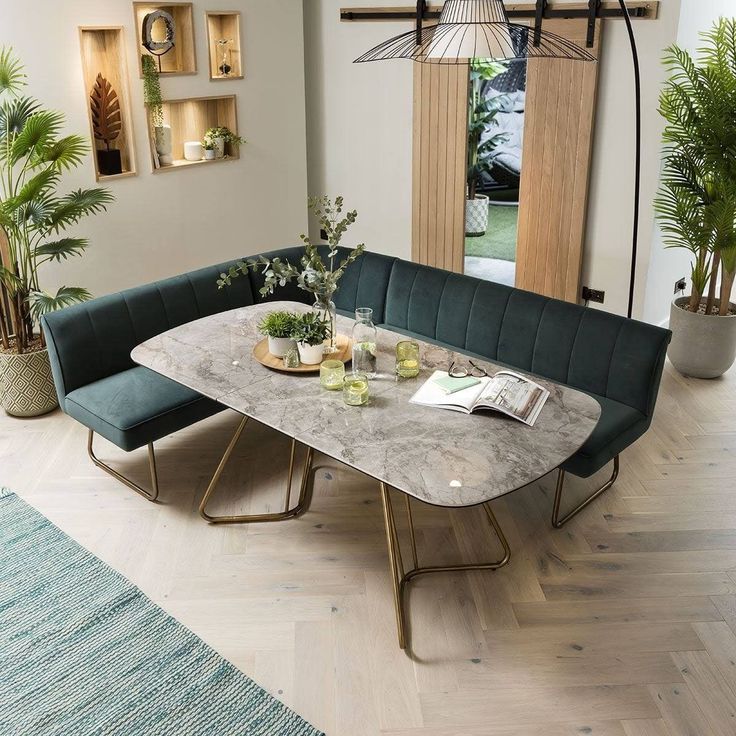 a dining room table with two benches and potted plants