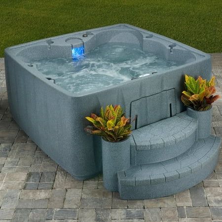 a large hot tub sitting on top of a brick patio