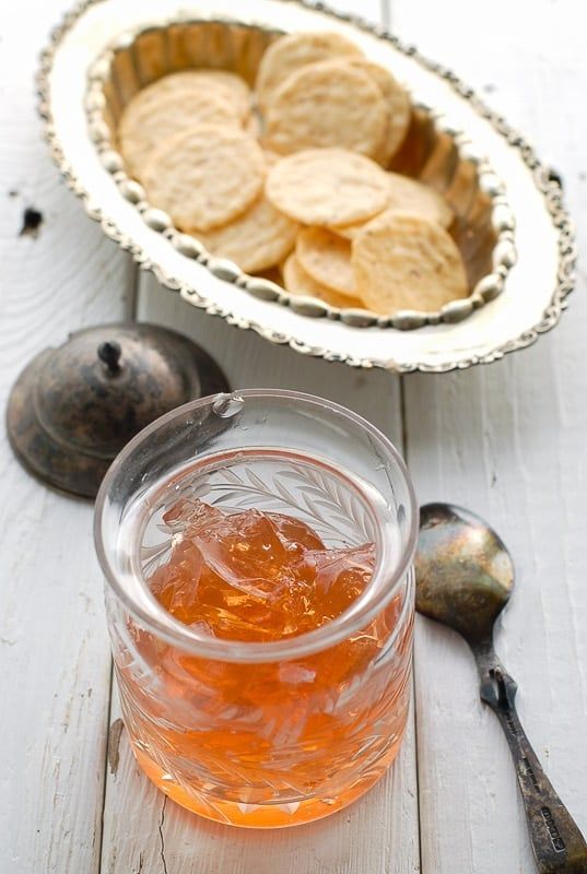 a bowl of crackers next to a glass of tea