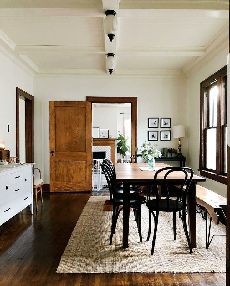 a dining room table with chairs and a rug on the floor in front of it