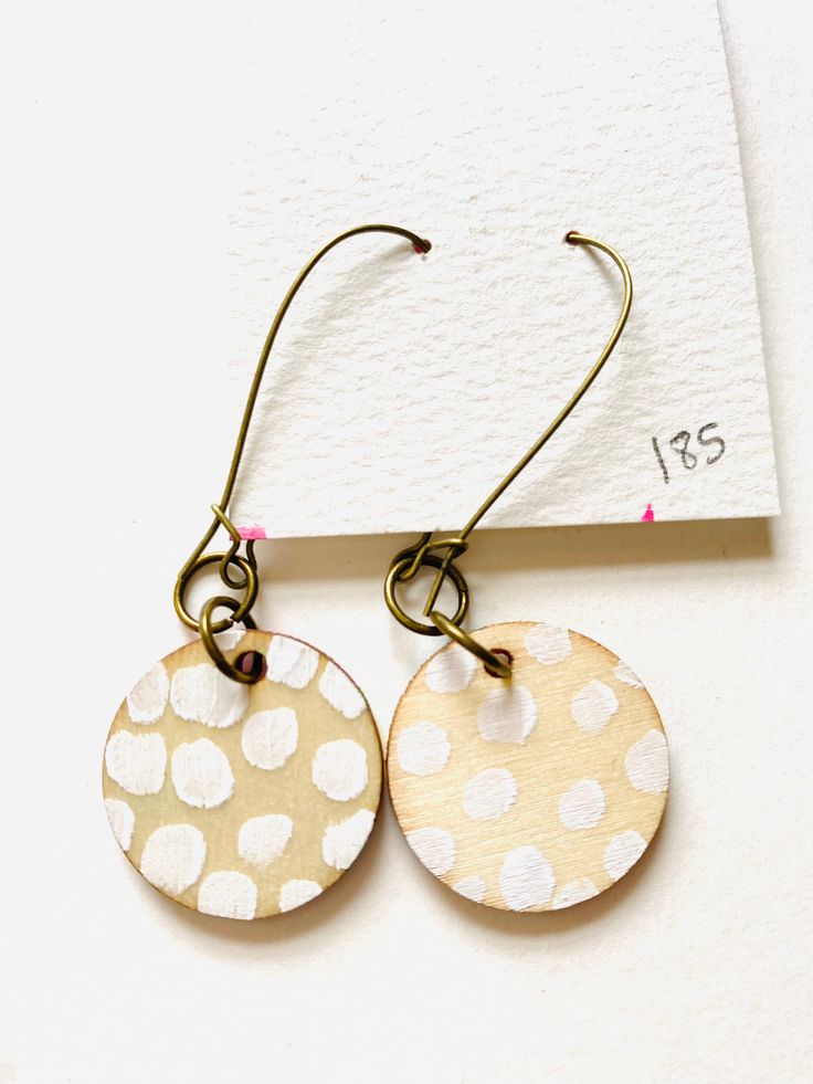 Art adorns your home and spaces but have you ever wanted to wear art in a fun, unique way? I've created these mixed media earrings with you in mind! Trendy hand painted earrings are ready to help you make a statement! Did I mention that they're double sided, too? The front side features a bold, abstract painting with gold shimmery accents and the back is complete with a fun pattern painted in white. Very light weight and easy to wear! What they're made with: - light weight wooden disc - acrylic Artistic White Drop Earrings, Artsy White Drop Earrings, Artsy White Pierced Earrings, Artsy White Earrings, Artistic Hand Painted White Earrings, Unique Hand Painted White Earrings, Artistic White Round Earrings, Artistic White Nickel-free Earrings, Hand Painted Bohemian Earrings For Everyday