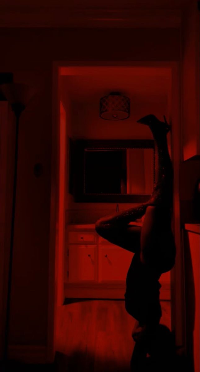 a person standing in a dark room with red light